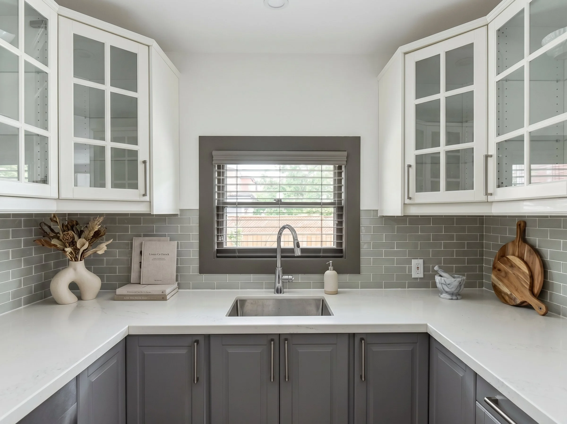 Custom kitchen featuring shaker cabinetry, quartz countertops and window above sink.