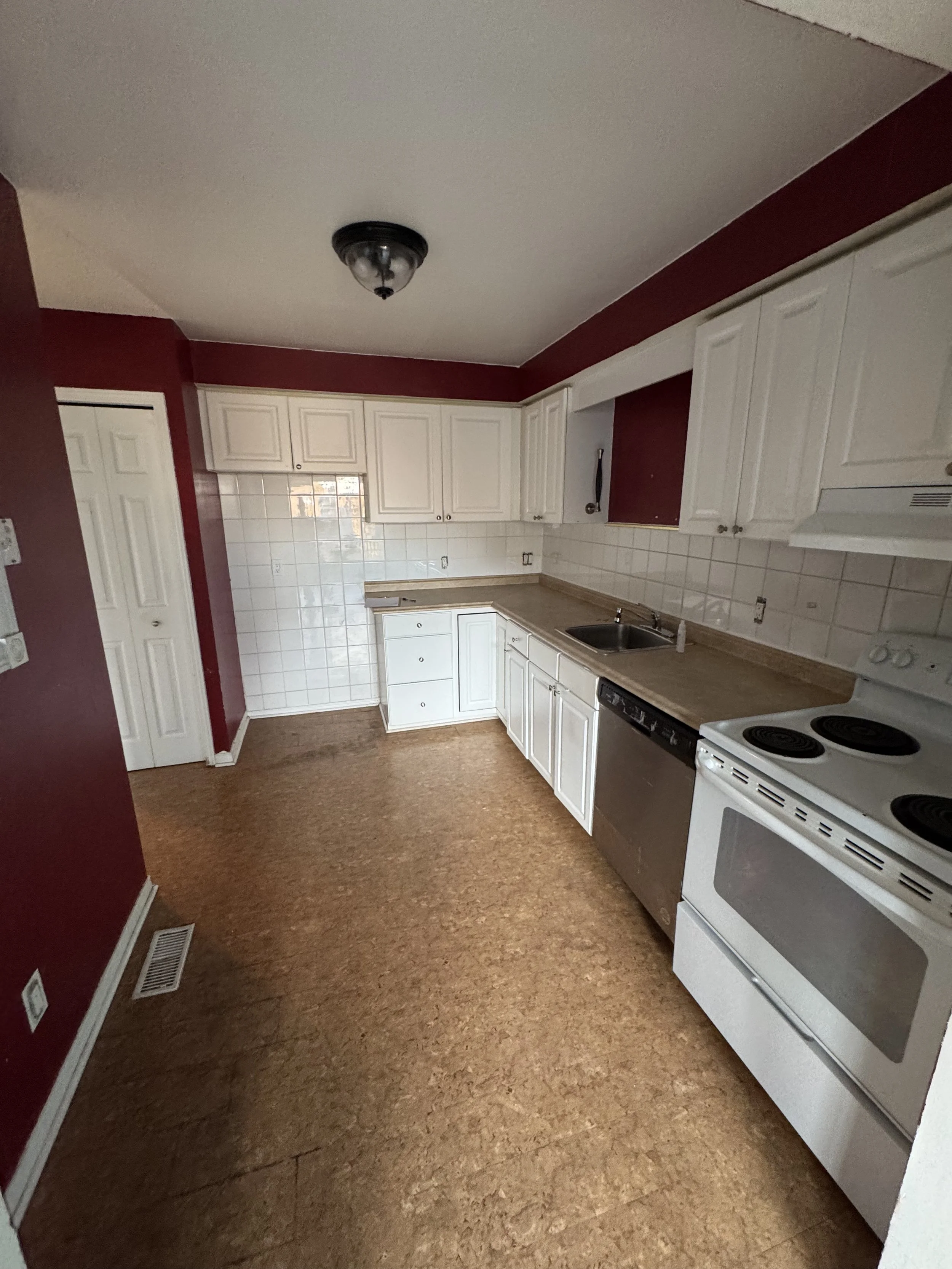 Original kitchen with dated cabinetry and colour palette before renovation.