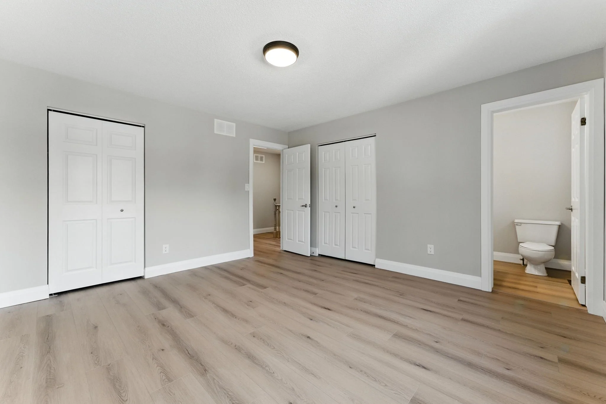 Updated bedroom featuring new flooring, trim, baseboards and fresh contemporary finishes.