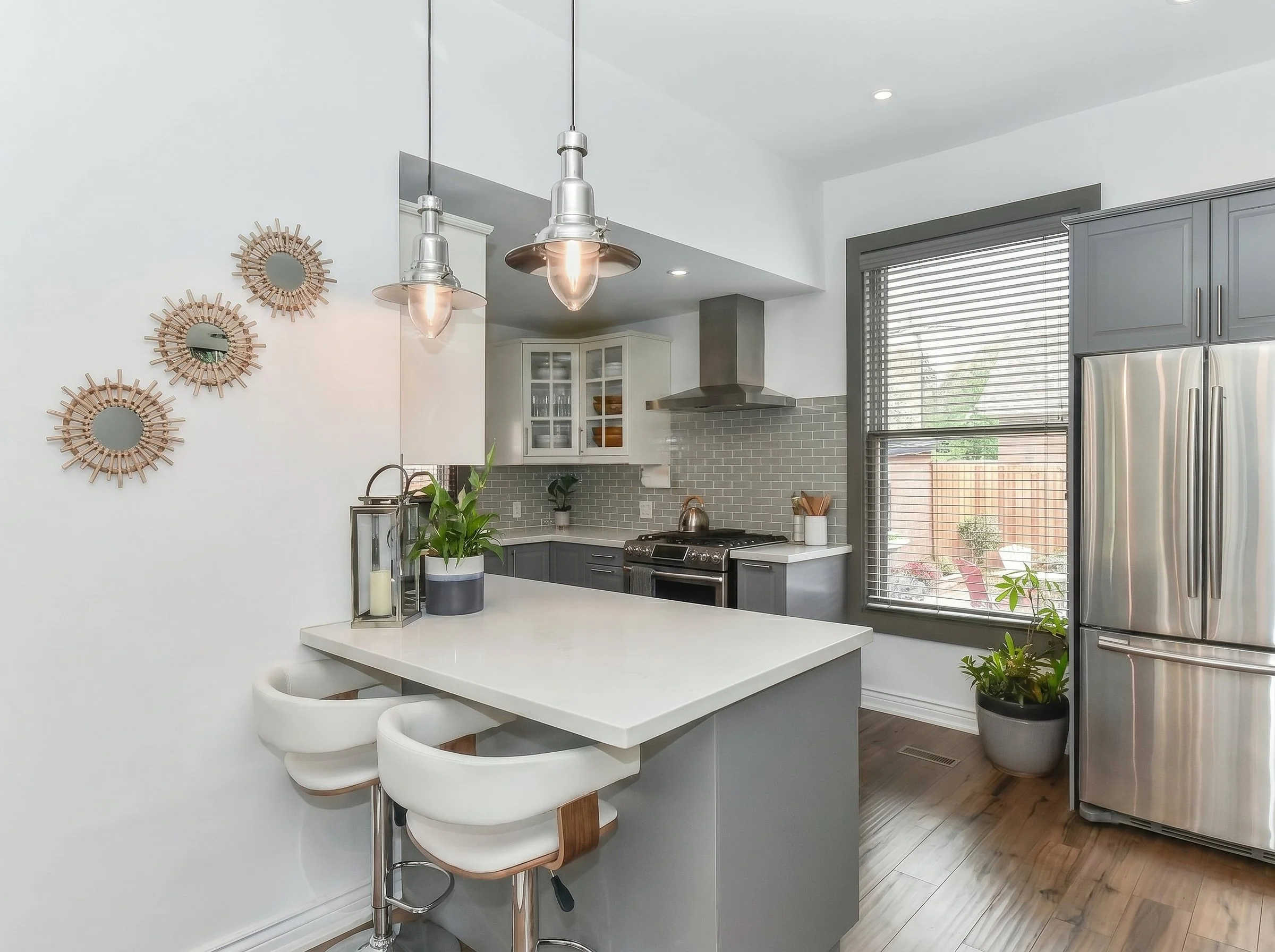 Bright finished kitchen with abundant natural light, modern cabinets, backsplash, quartz countertops, engineer hardwood floor