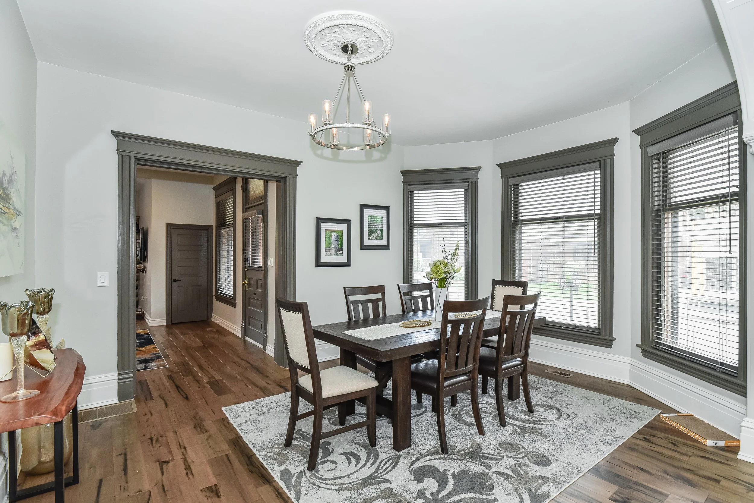 Bright dining room with large windows, engineered hardwood flooring and open-concept design.