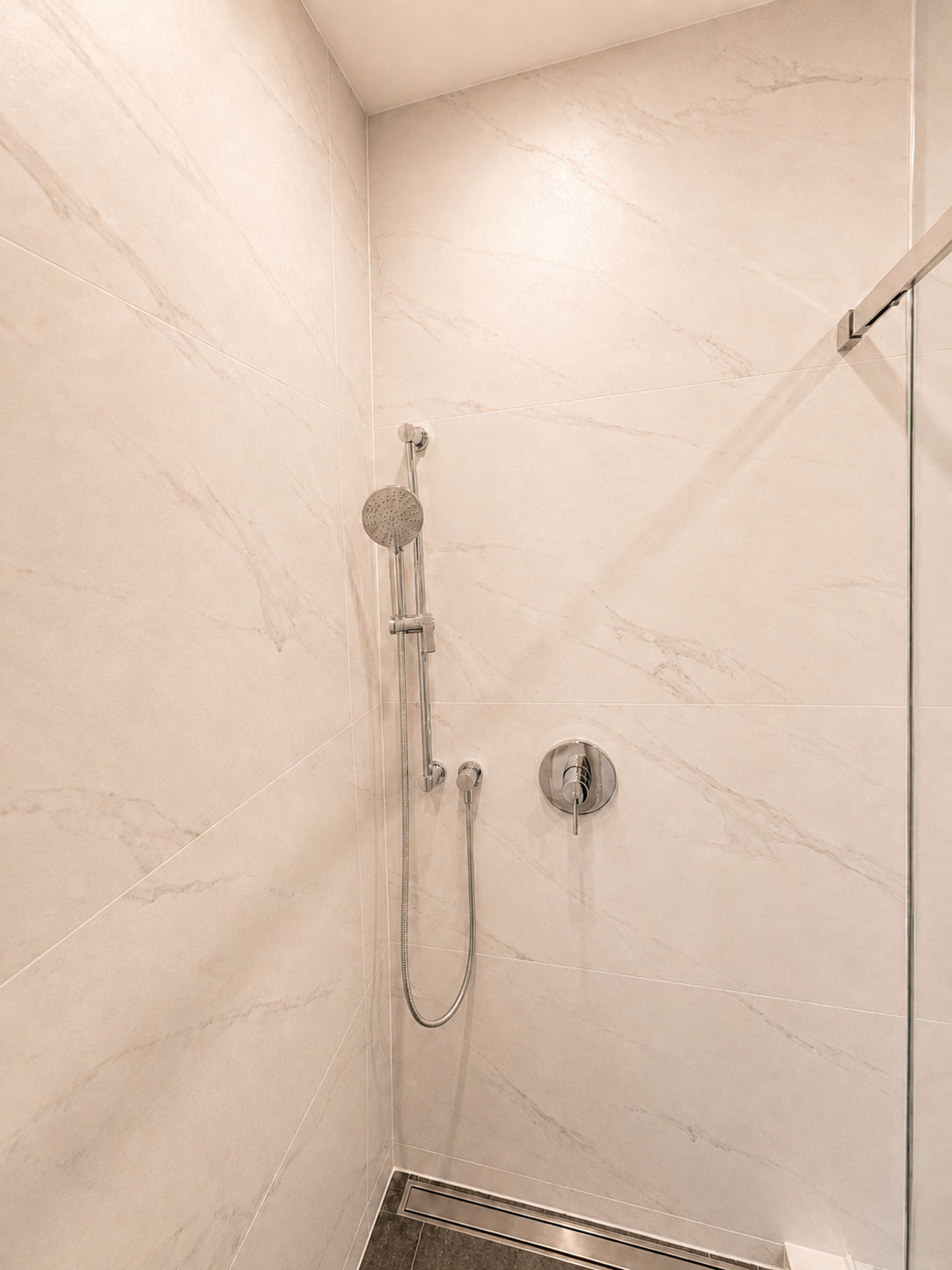 Modern shower fixtures installed in the completed walk-in shower.