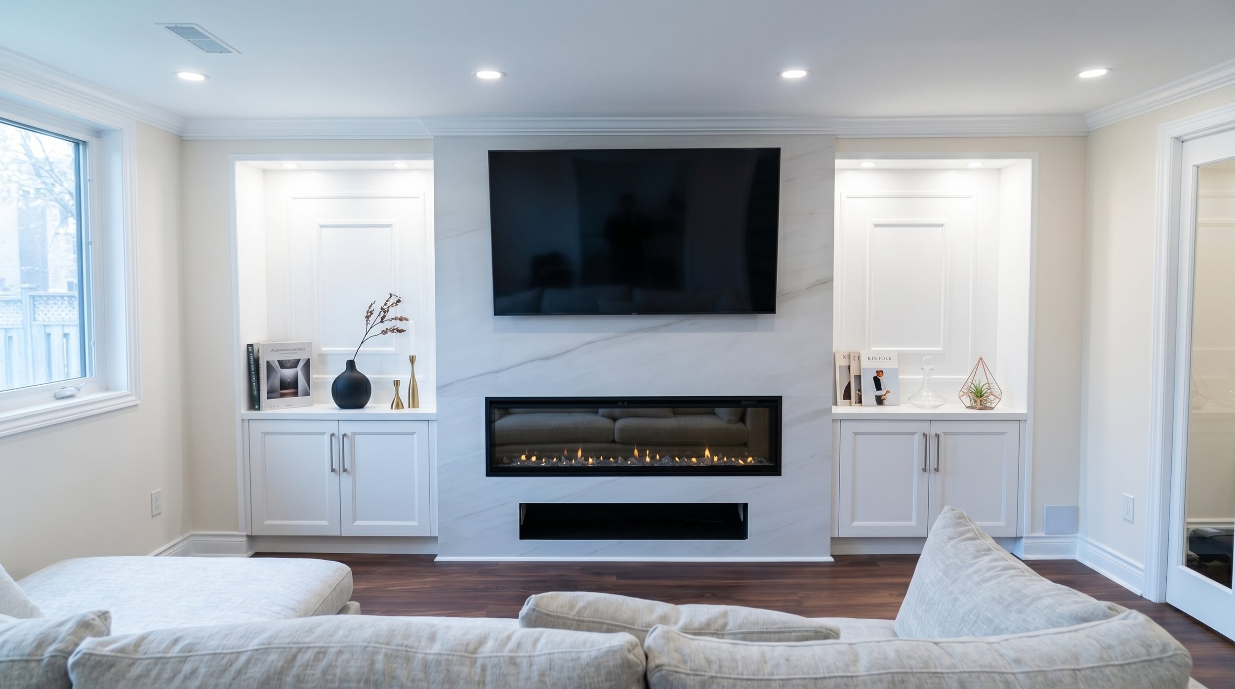 Finished basement with a custom fireplace feature wall, built-in cabinetry and integrated media center.