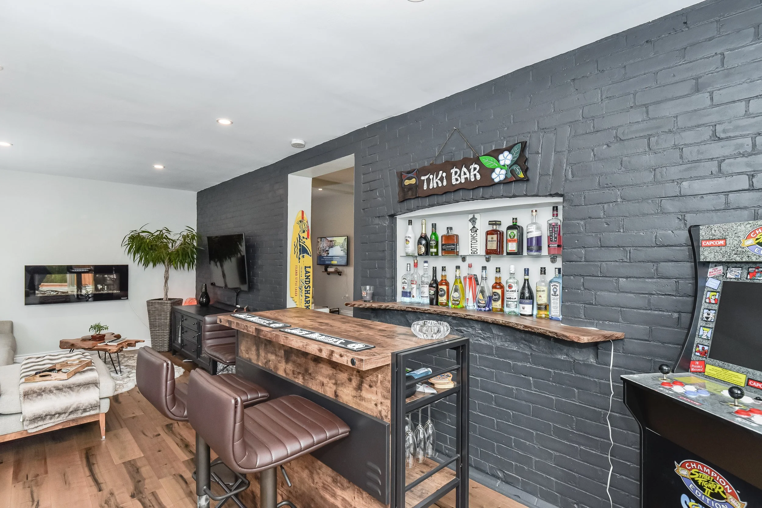 Custom home bar with wood countertops, feature wall with exposed bricks, and built-in beverage storage.