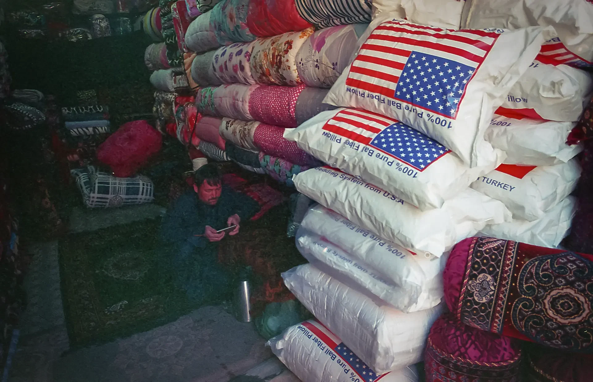 Documentary street photography capturing stacks of goods featuring flag patterns, USA Bazar,Kabul, Afghanistan.