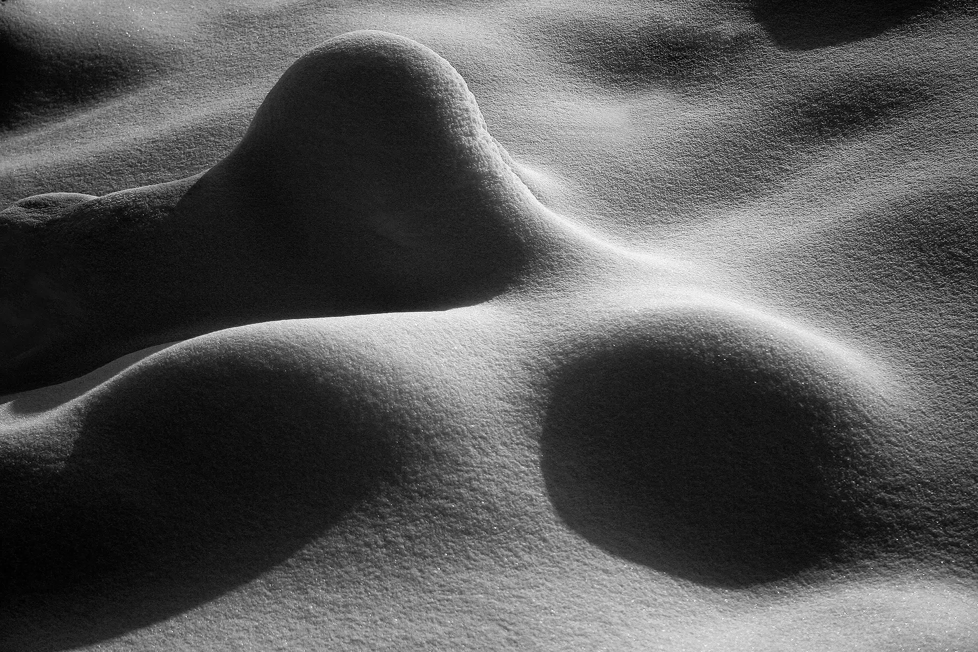 Abstract fine art photography from the "Written Lines" series, capturing a snowy day in the highlands of north Tehran, Iran. High-contrast minimalist landforms and deep shadow mounds
