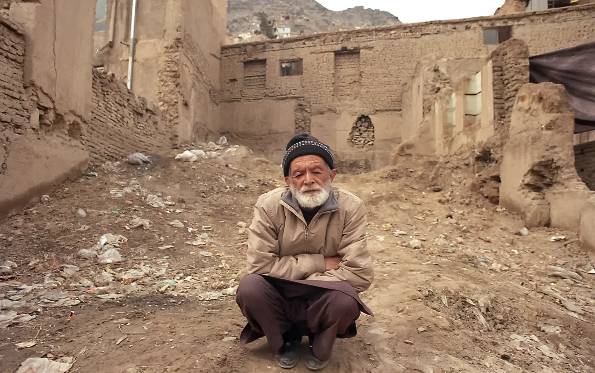 Poignant documentary portrait of an elderly man sitting by a brick wall, Kabul,  Afghanistan.⁠