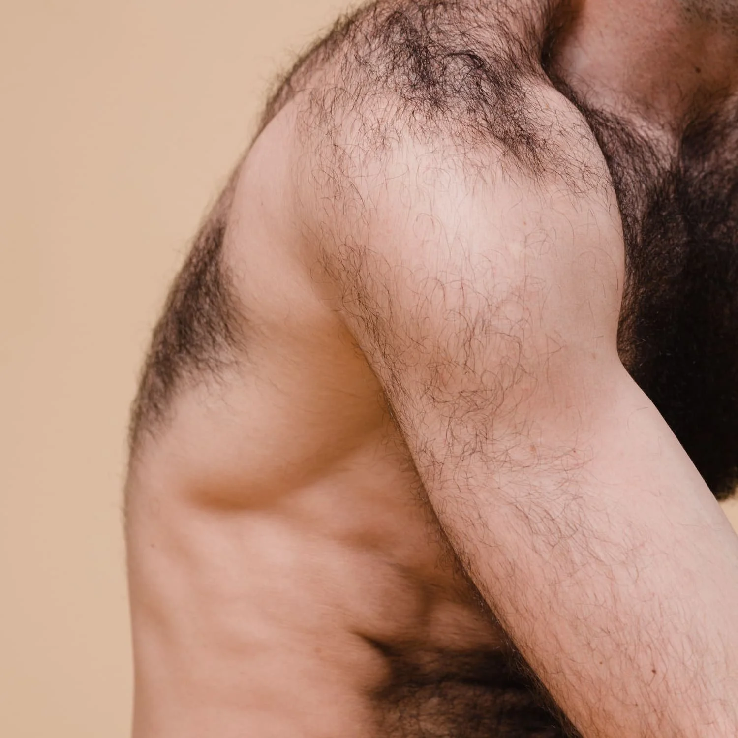 Close-up of a man's shoulder, chest, and armpit with visible hair and skin details.