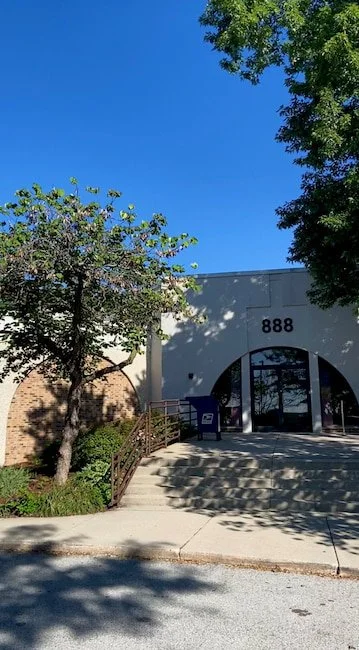 Building with the address 888, surrounded by trees and a clear blue sky.