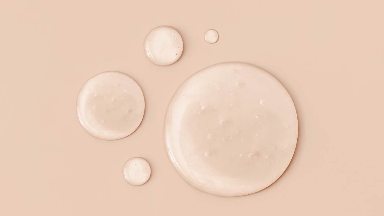 Several transparent soap bubbles with small bubbles inside on a beige background.
