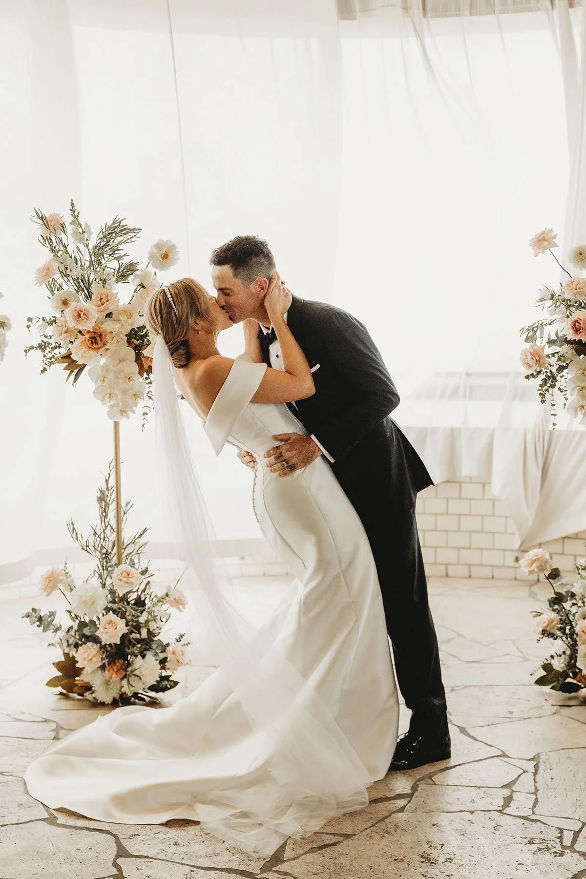 A bride and groom sharing a kiss during their modern wedding ceremony