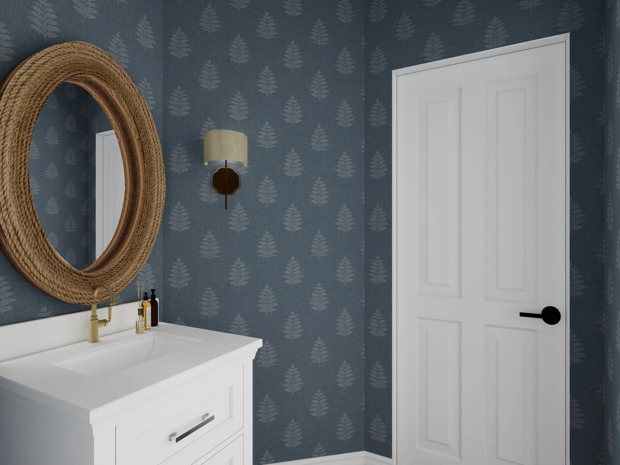 A bathroom with dark blue wallpaper featuring a white leaf pattern, a white vanity with a sink, gold faucet, and bottles on the countertop. A round mirror with a woven frame hangs above the vanity, and there is a wall-mounted lamp with a cream-colore