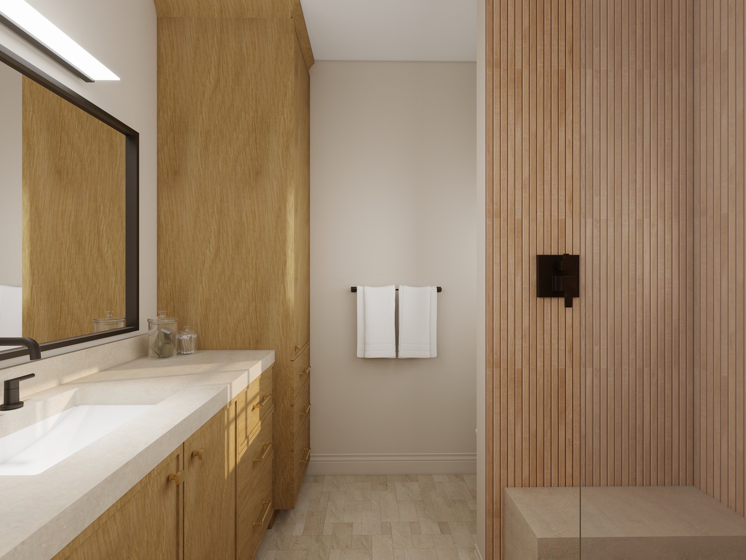 A bathroom vanity with a white countertop, black faucet, and two clear glasses. Light wood cabinets below, large mirror above, and a white towel on a rack on the wall. The wall has a wood panel accent on one side.