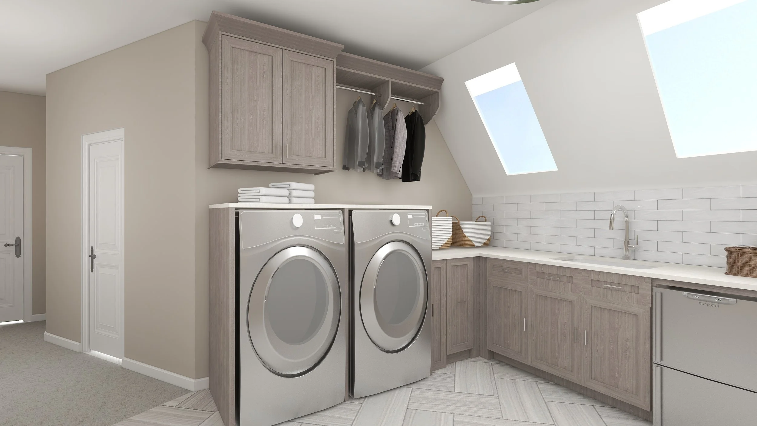 A laundry room with light wood cabinets, a front-loading washer and dryer, stacked towels, and a countertop with baskets near a sink under skylights.