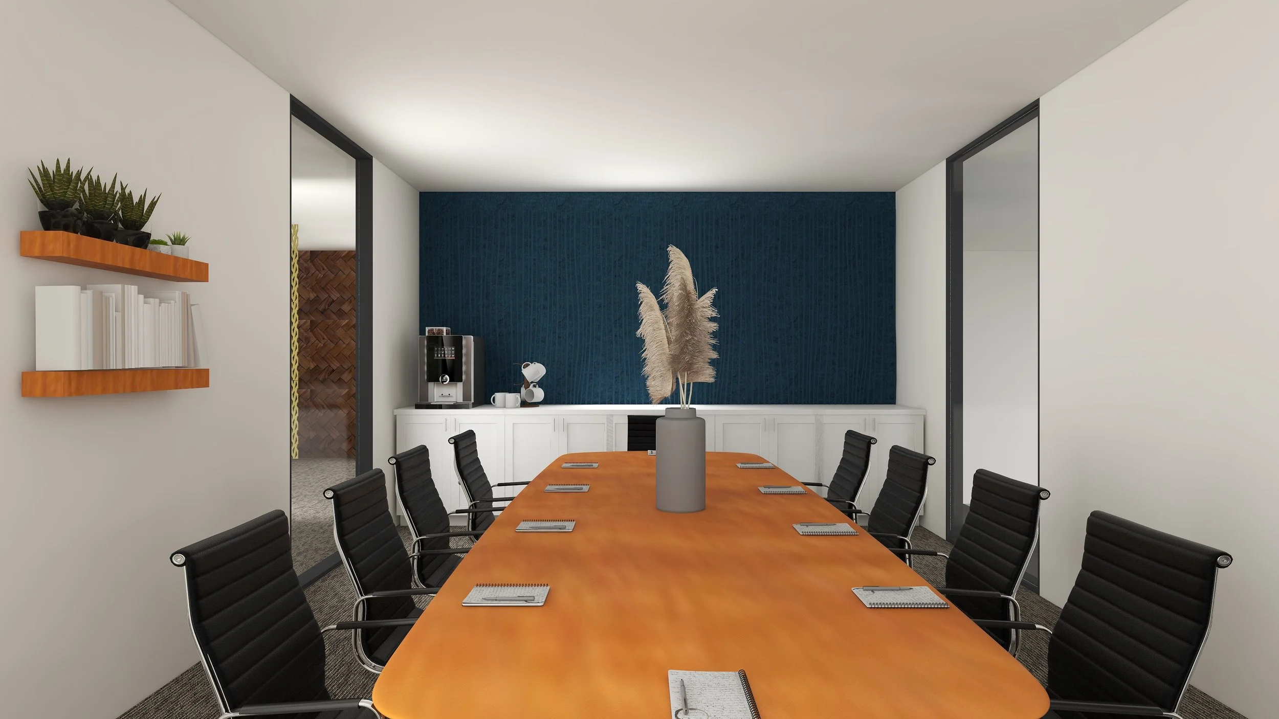 A modern conference room with a long wooden table surrounded by black chairs, a blue textured accent wall, a large white shelf with a coffee machine and decor, a vase with pampas grass as a centerpiece, and a wall-mounted shelf with books and plants.