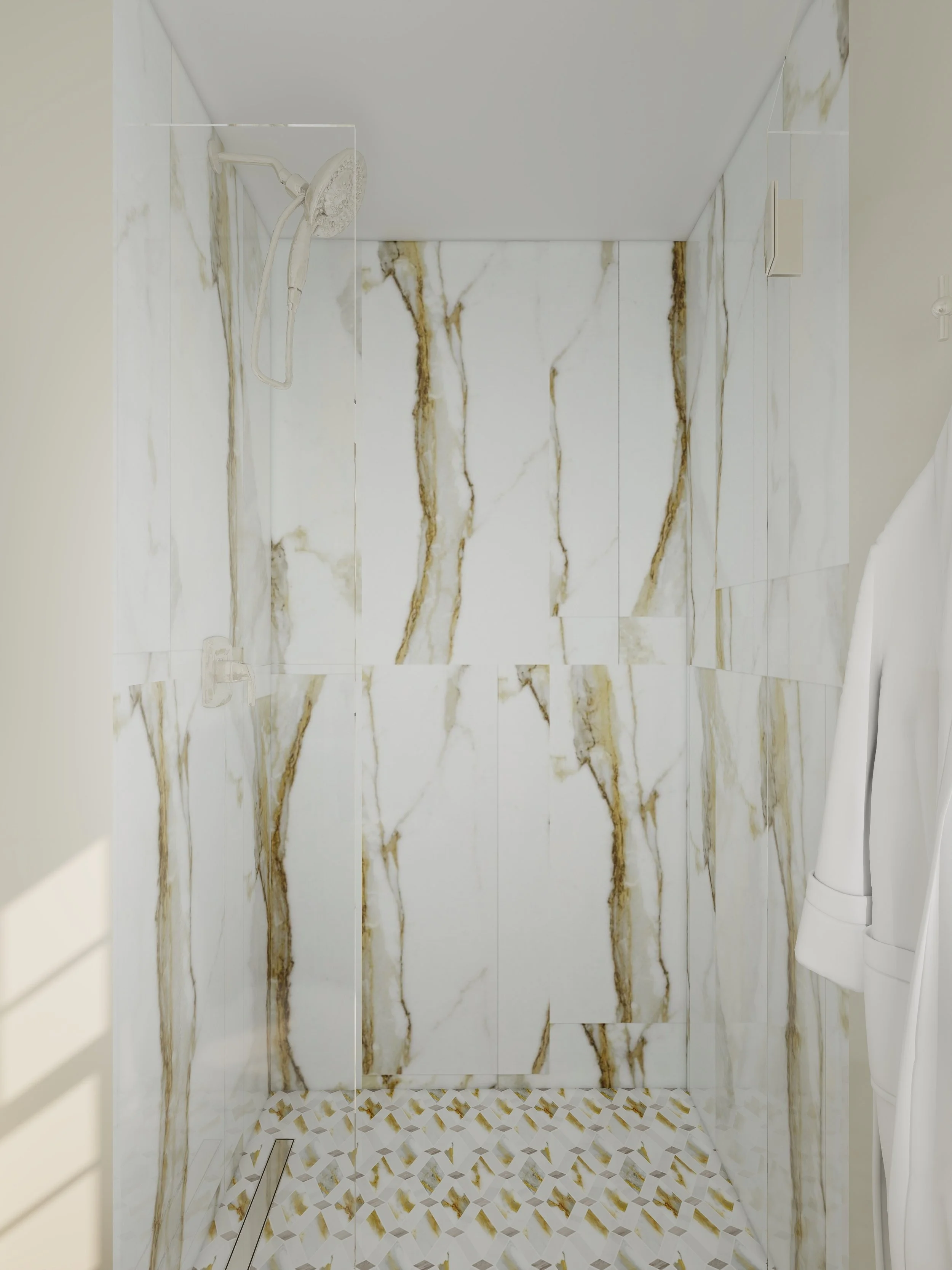 Marble tiled shower with a handheld showerhead, a small drain on the floor, and a partial view of a white towel on the right side.