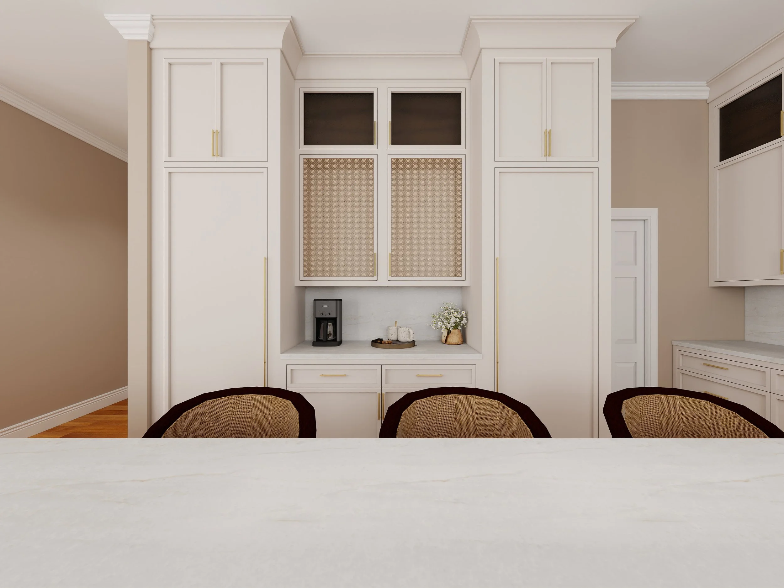 Kitchen with white cabinets, gold handles, a coffee maker, and a tray with decorative items, viewed from a table with chairs.