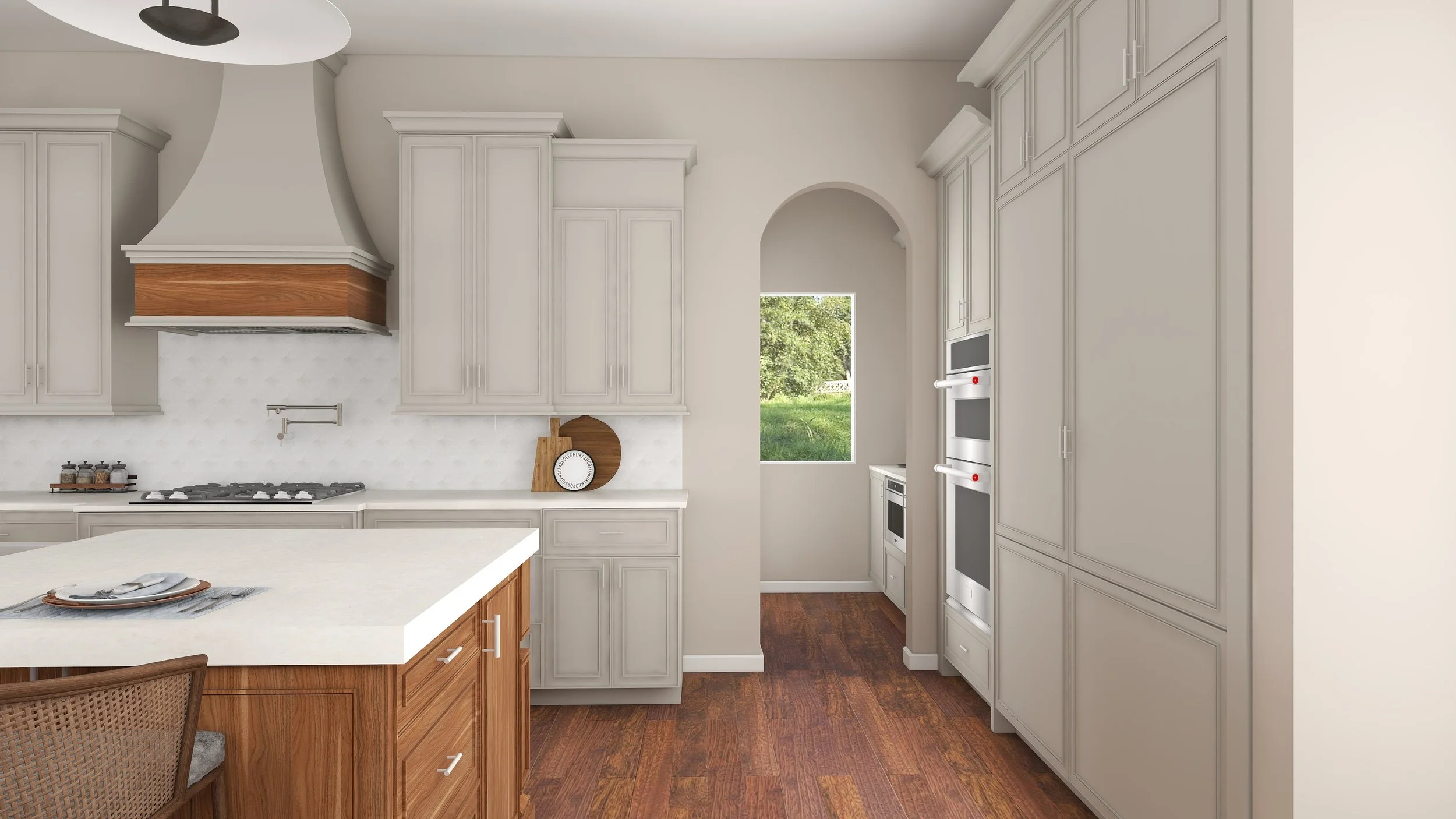 A kitchen with beige cabinets, white countertops, and wooden lower cabinets. There is a gas stove with a wooden range hood. A window shows greenery outside, and there is a double oven built into the cabinets.