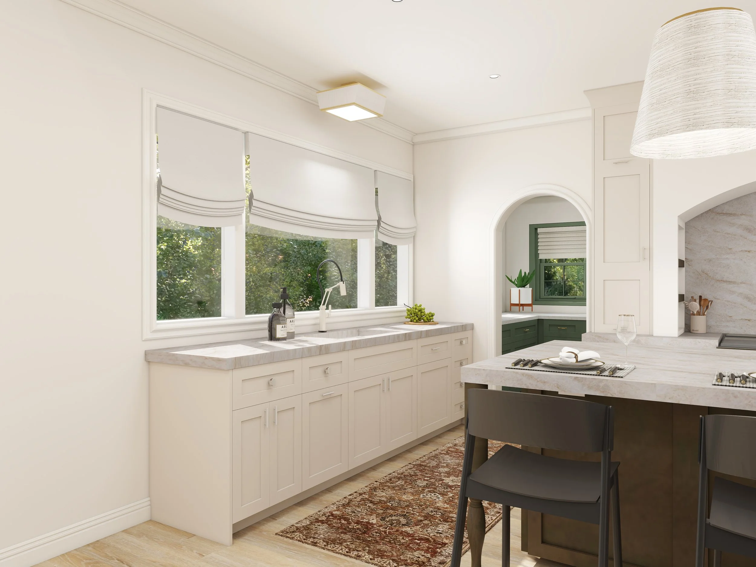 A bright kitchen with white cabinets and marble countertops. Large windows with white roman shades let in natural light. There is a black chair at the island, a glass, and some kitchen utensils. Pendant lighting is installed in the ceiling, and a sma