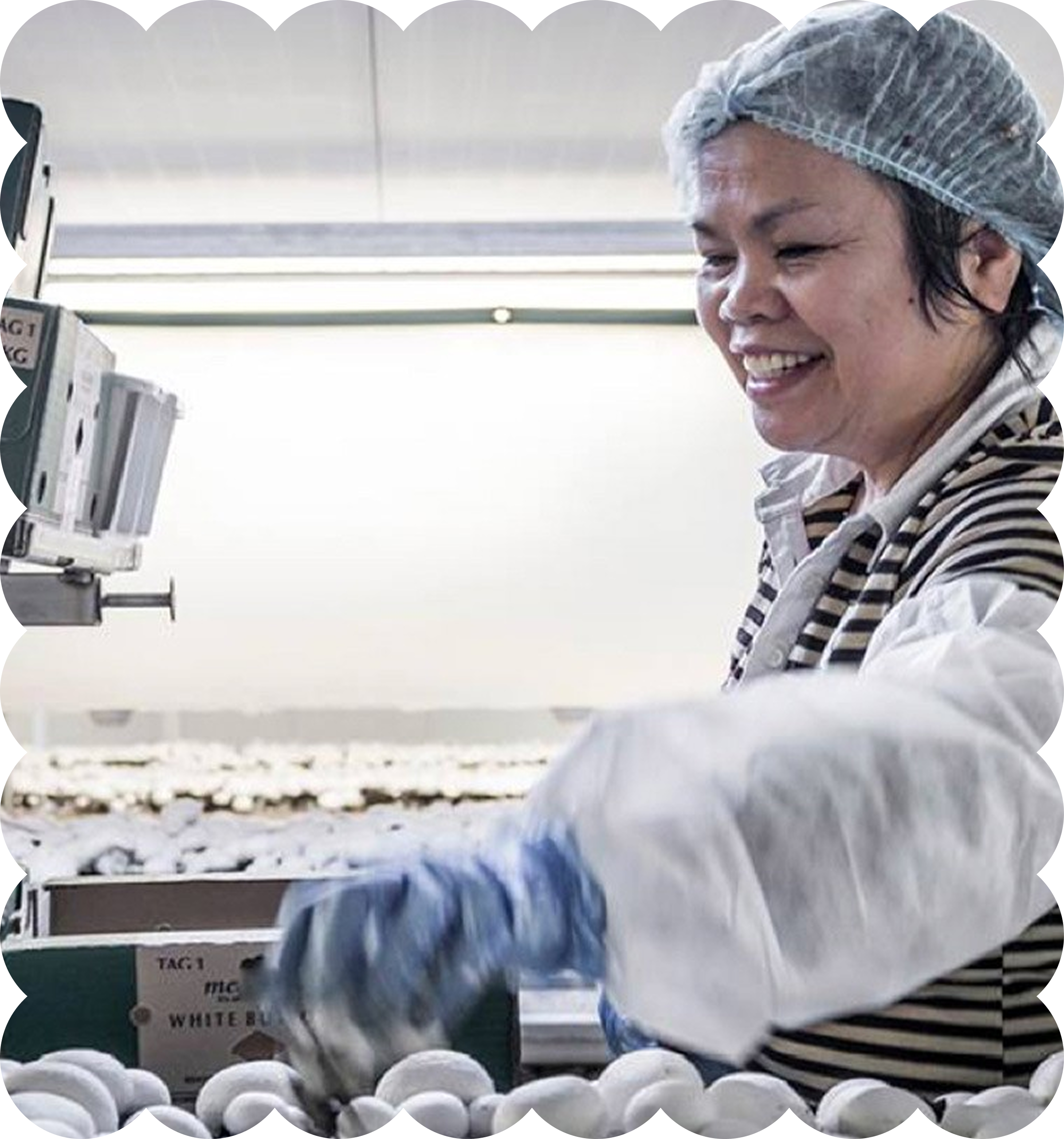 A woman wearing a hairnet, smiling in a production or packaging facility with white eggs and cartons in the foreground.
