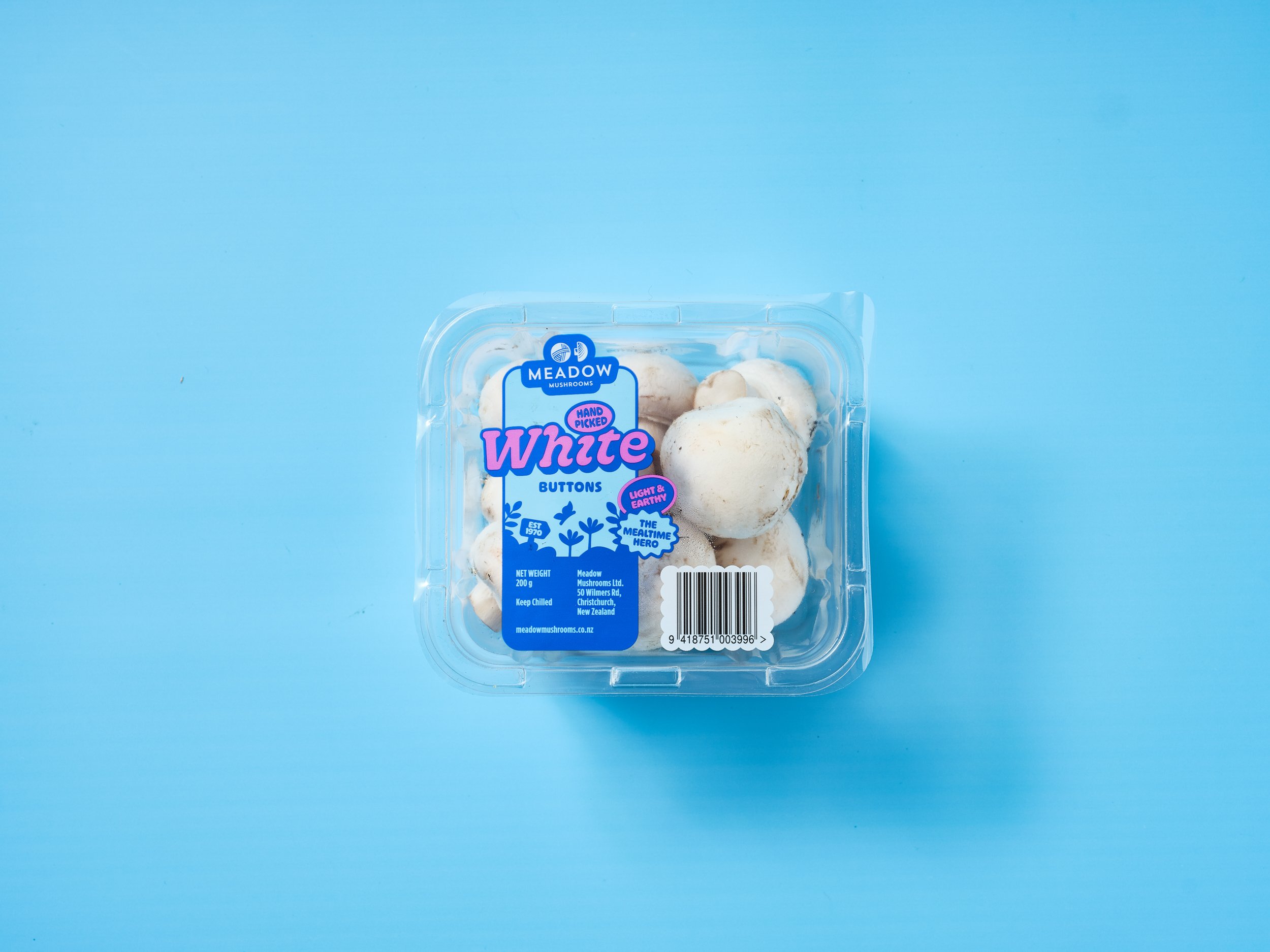 Package of white button mushrooms on a light blue background.
