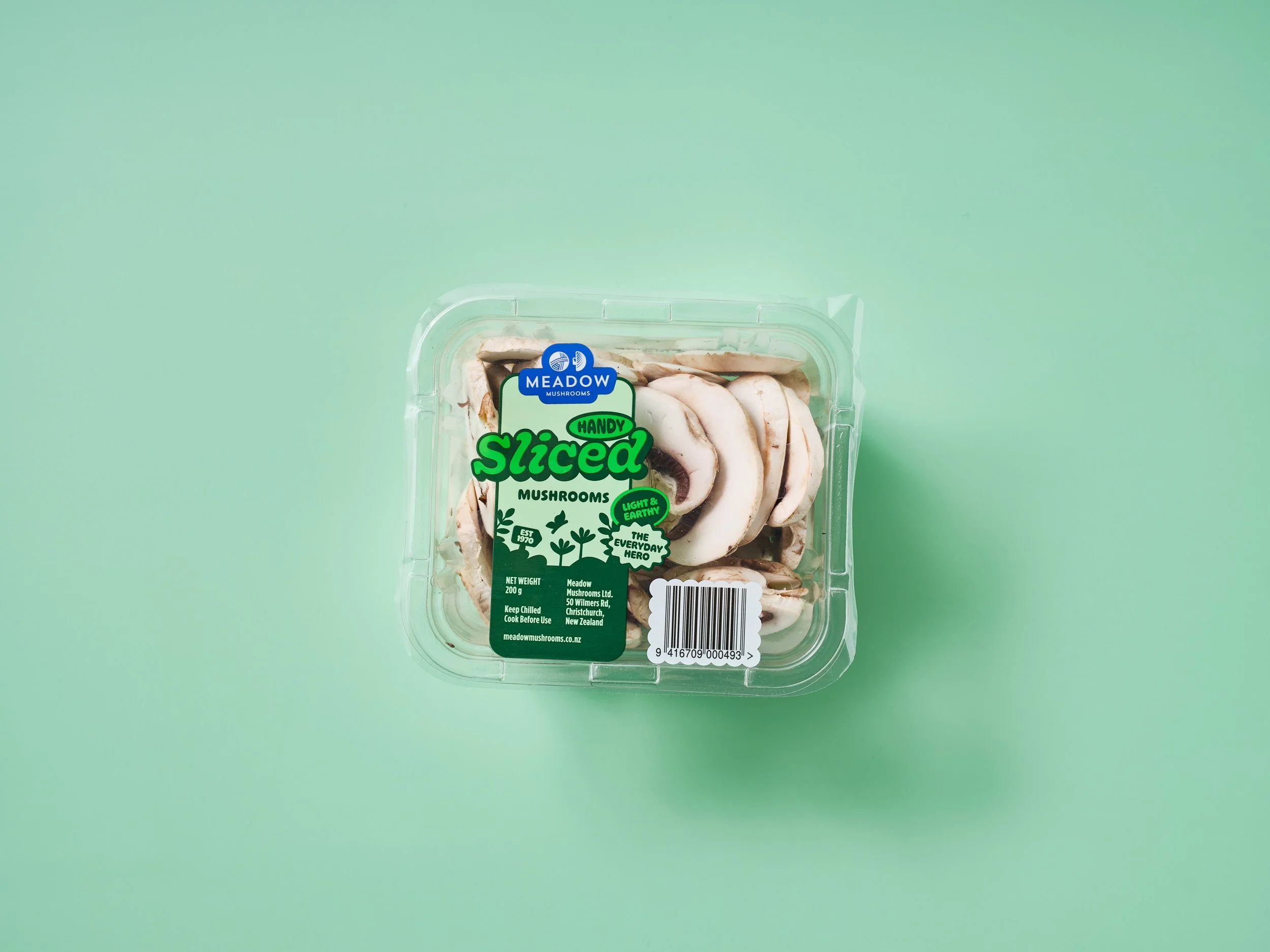 Packaged sliced mushrooms from Meadow Mushrooms Ltd, with labels indicating they are handy, sliced, light and earthy, and the primary background is a solid light green.