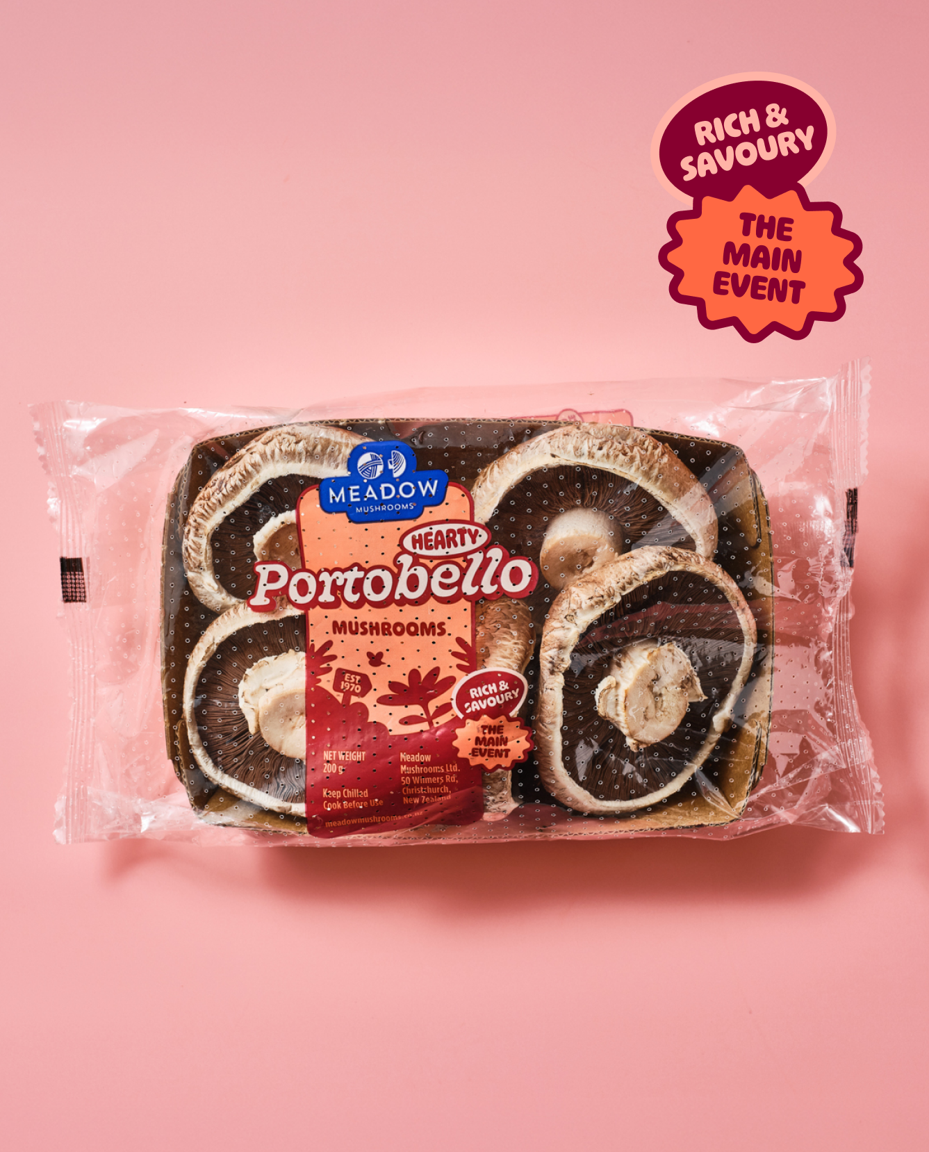 A package of Meadow Mushrooms Portobello with sliced portobello mushrooms inside, on a pink background with a label indicating main event and rich flavor.
