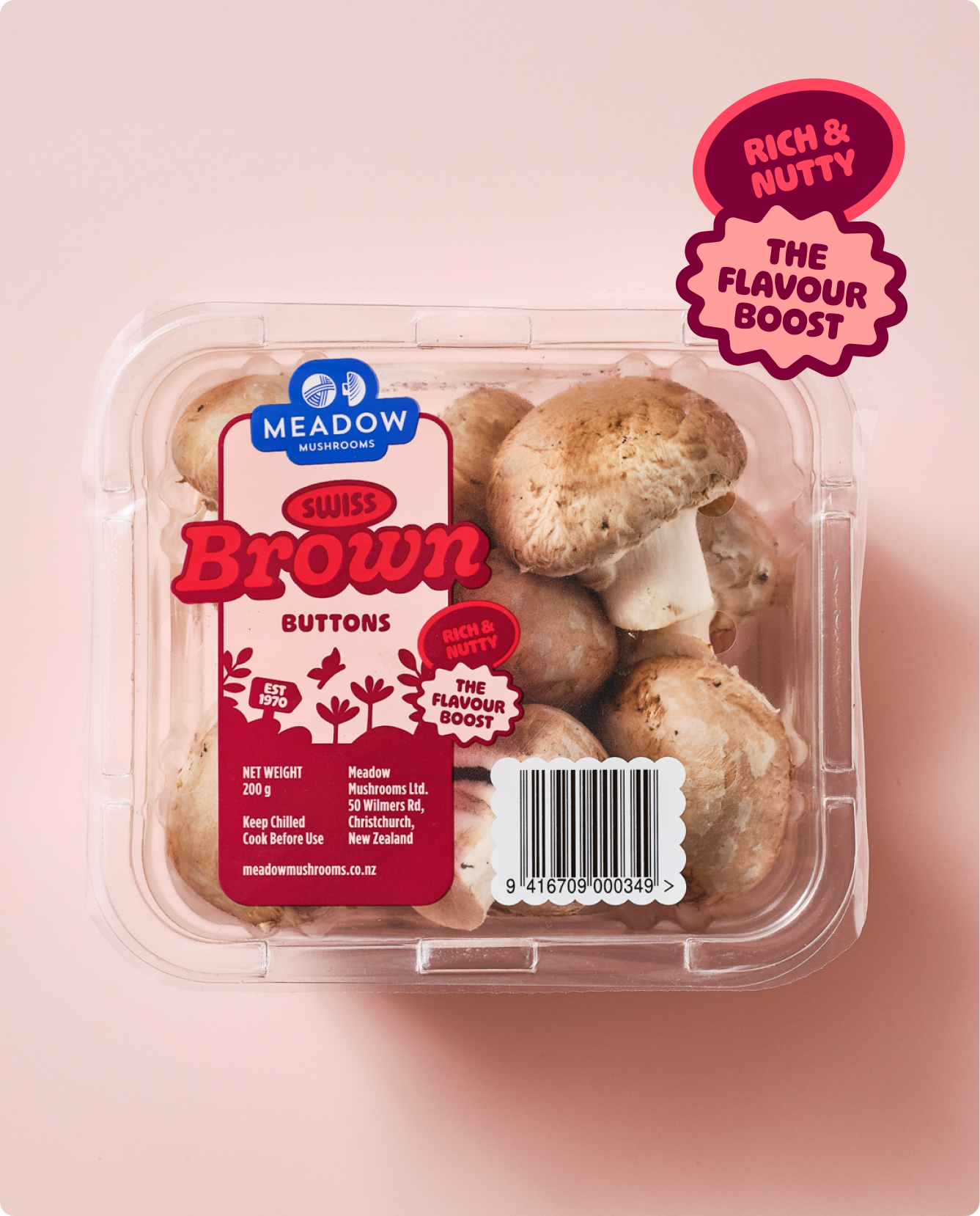 A clear plastic container of meadow mushrooms with labels indicating they are Swiss Brown Buttons, with branding and promotional stickers highlighting flavor and nuttiness.