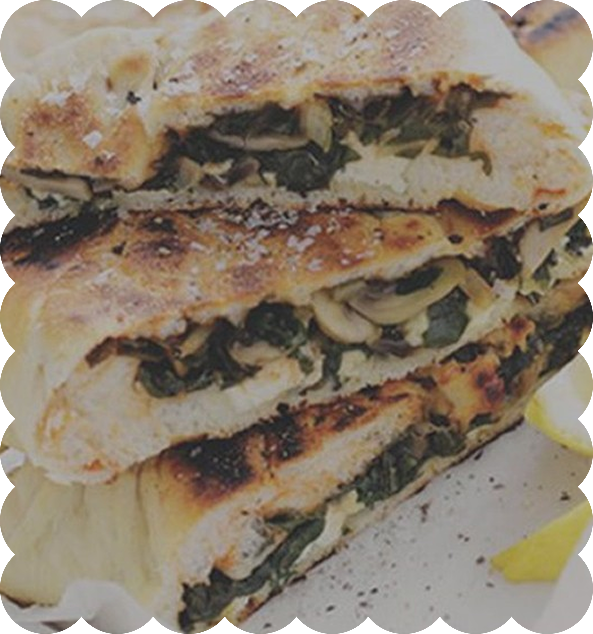 Close-up of a slice of layered lasagna with cheese, mushrooms, spinach, and sauce.