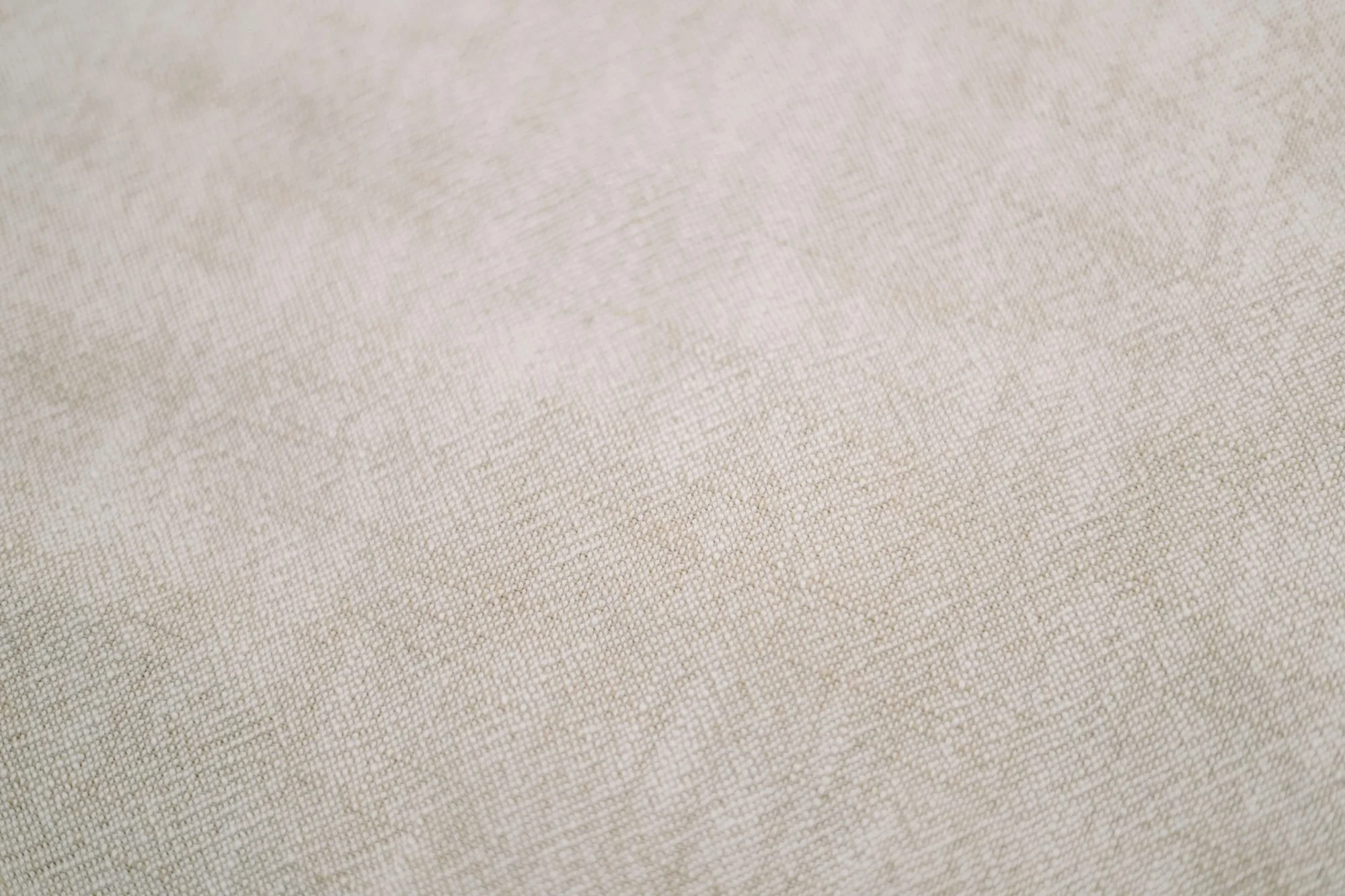 Close-up of beige fabric with a woven texture.