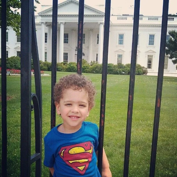 Rashad’s young son smiling by the White House fence