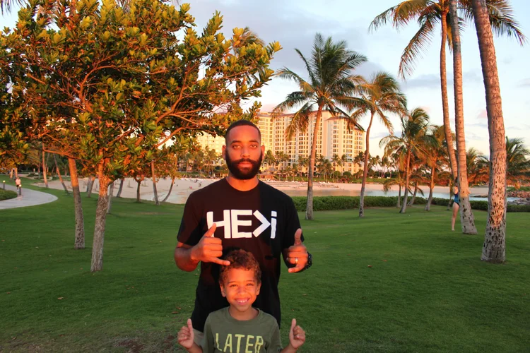 Father and child beneath palm trees
