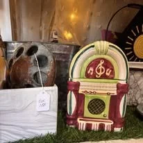 Decorative vintage radio with a jukebox design, green and red color scheme, beige top, and musical note symbols.