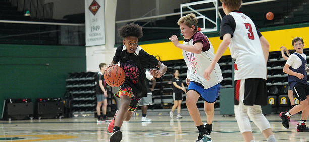 Children playing basketball on an indoor court.
