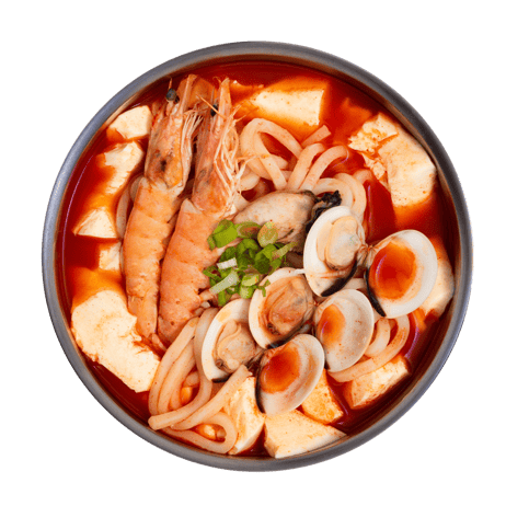 Bowl of spicy seafood noodle soup with shrimp, mussels, tofu, chopped green onions, and an egg in a red broth.