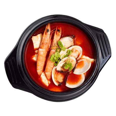 Spicy seafood stew with shrimp, mussels, and boiled eggs garnished with green onions in a black bowl