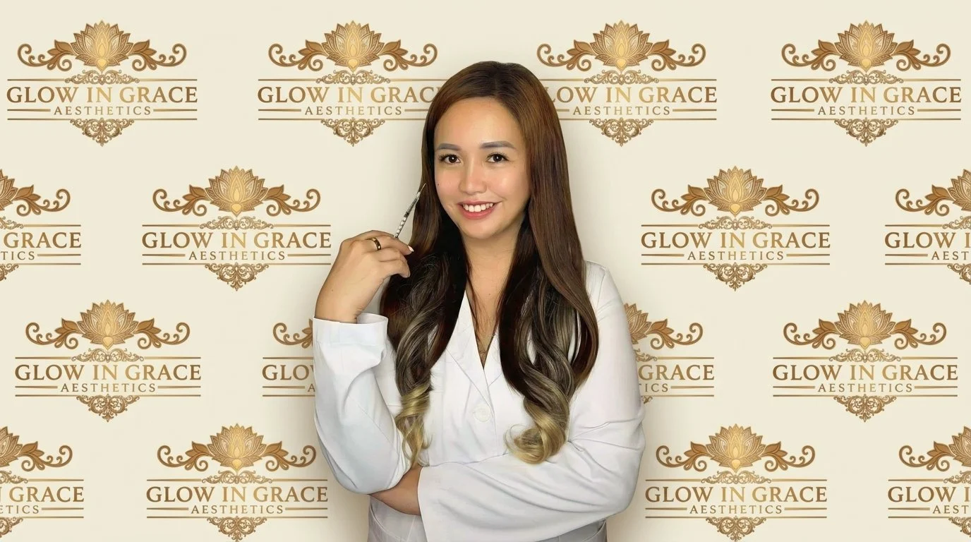 A woman with long wavy hair holding a syringe in front of a backdrop with the logo 'Glow in Grace Aesthetics' repeated multiple times.