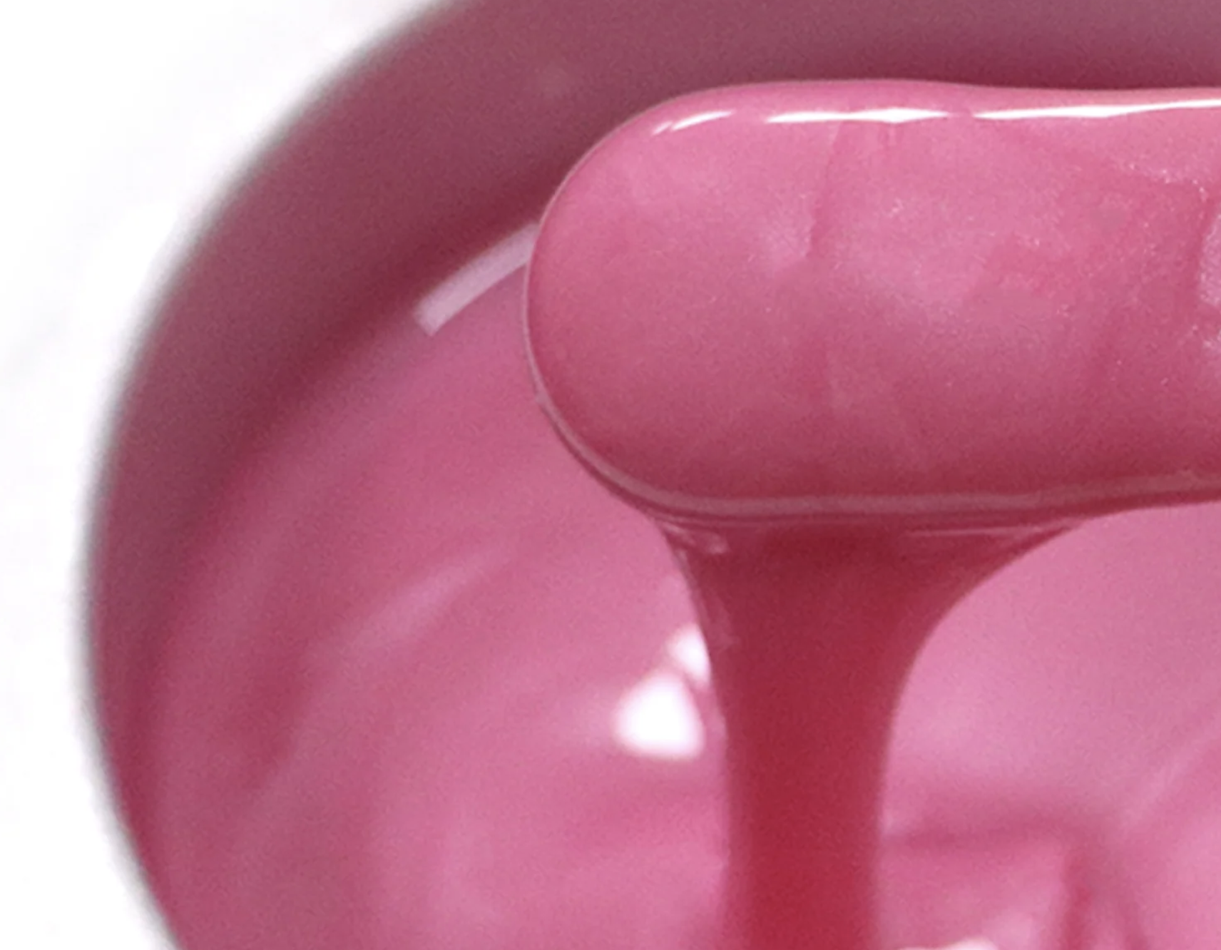 A spatula of warm pink hair removal wax.