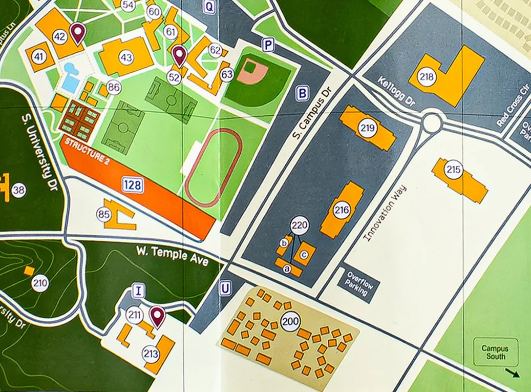 Map of a campus showing buildings, sports fields, parking lots, and roads labeled with street names.