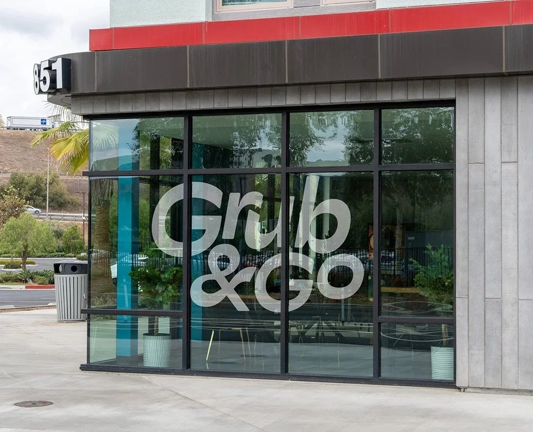 The storefront of Grab & Go, a small retail space with large glass windows and the store's name in large white letters on the window.