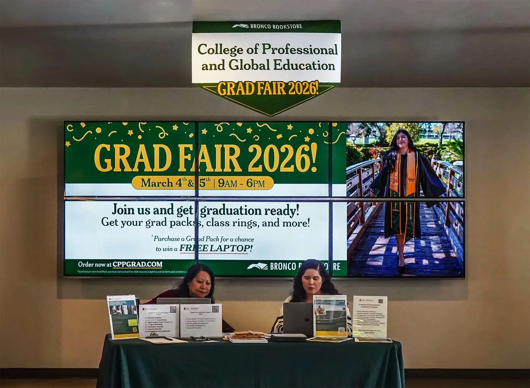 Digital display promoting the College of Professional and Global Education Graduate Fair 2026, scheduled for March 4th and 5th from 9 AM to 6 PM, with information about graduation readiness and a chance to win a free laptop, at Bronco Bookstore.