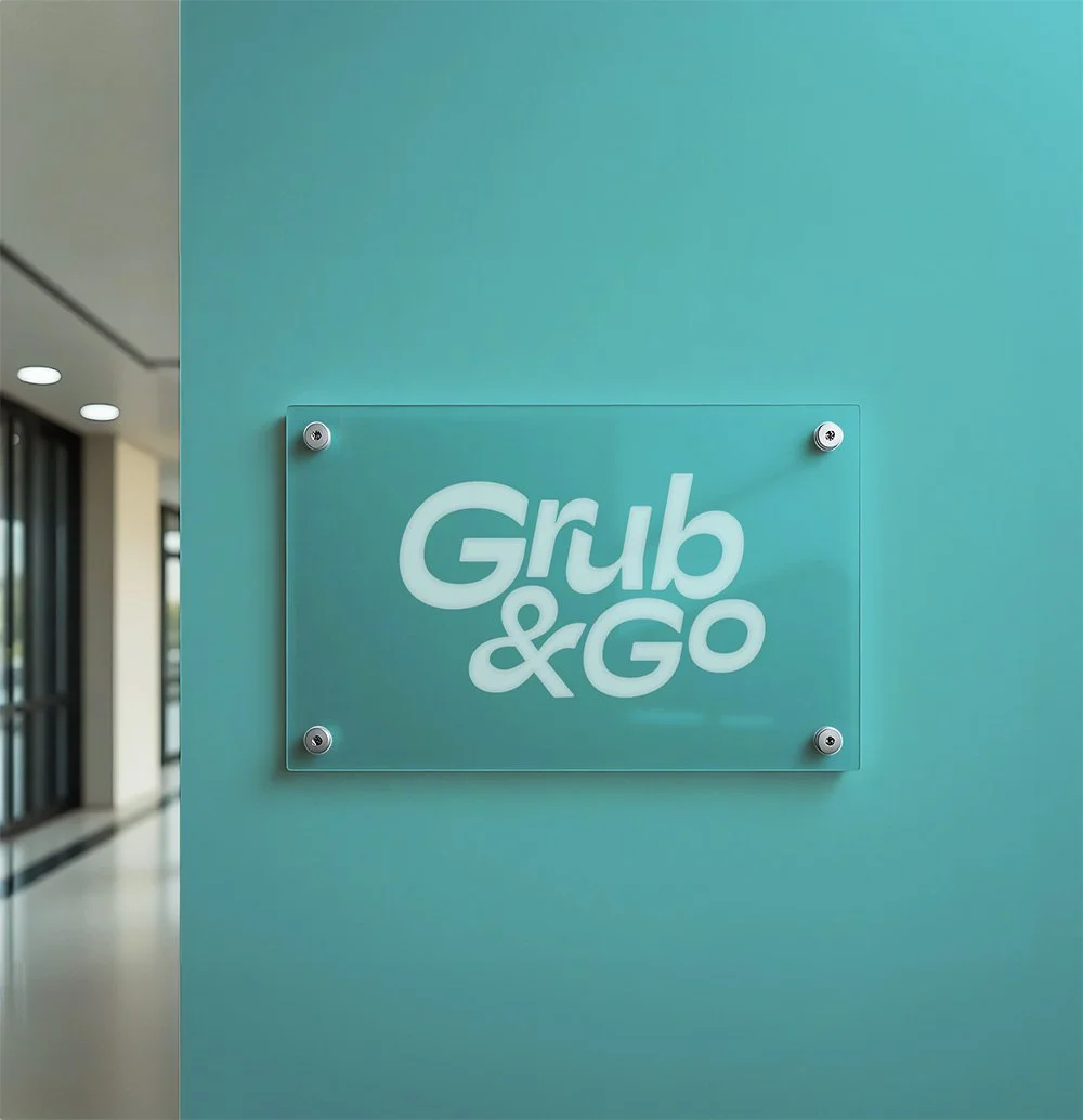 A sign that reads 'Grub & Go' on a glass panel mounted on a teal-colored wall