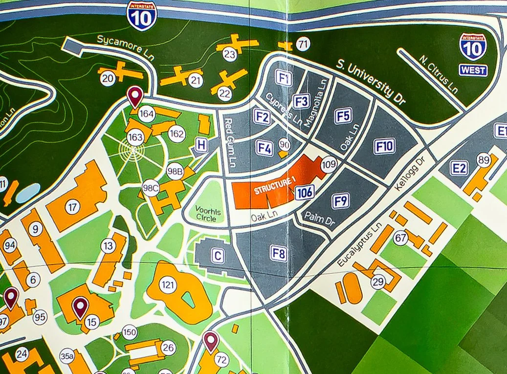 A detailed campus map showing various buildings, roads, and landmarks, highlighting structures, parking areas, and nearby interstate 10.