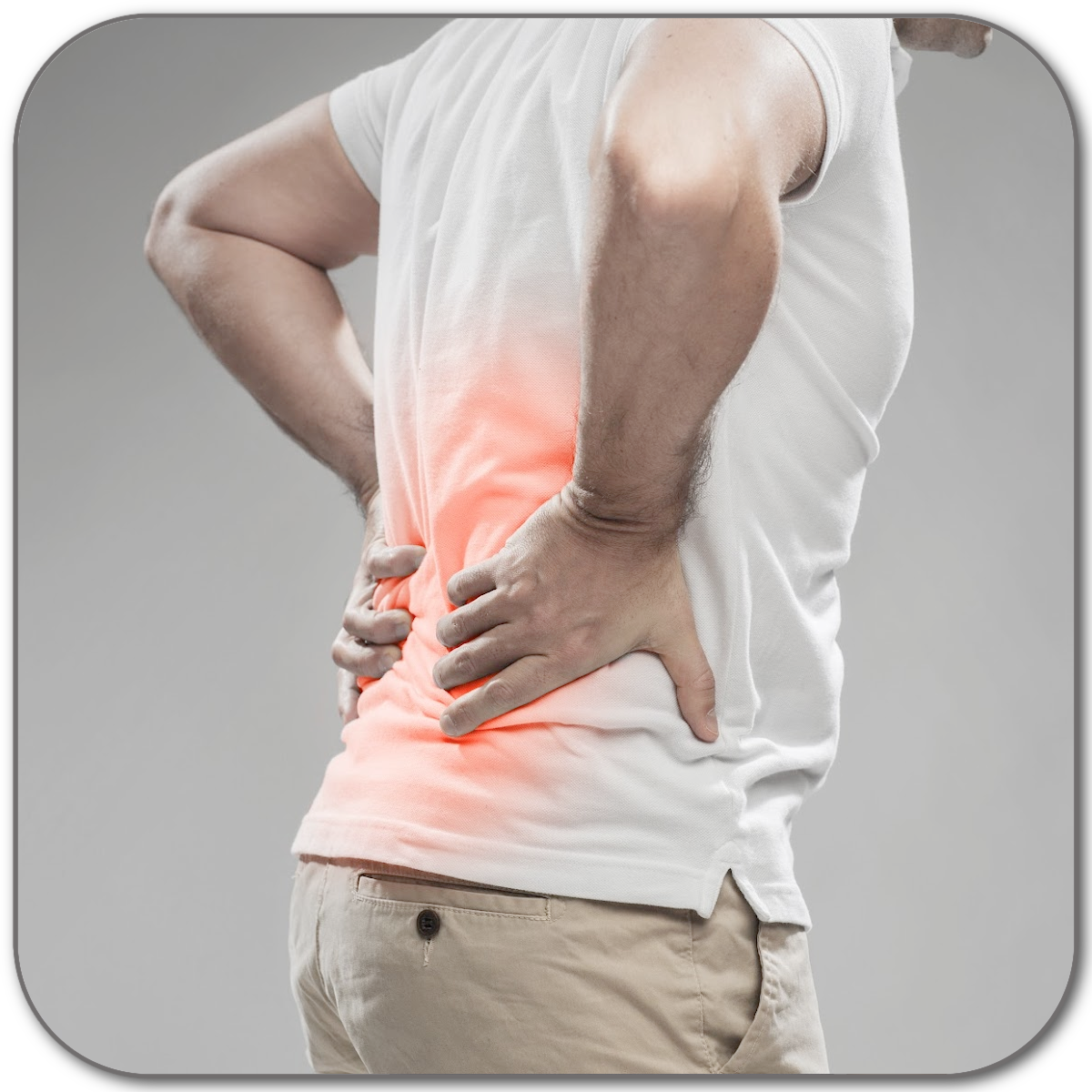 Man in a white t-shirt and beige pants holding his lower back, which is highlighted in red to indicate lower back pain or lower back discomfort.