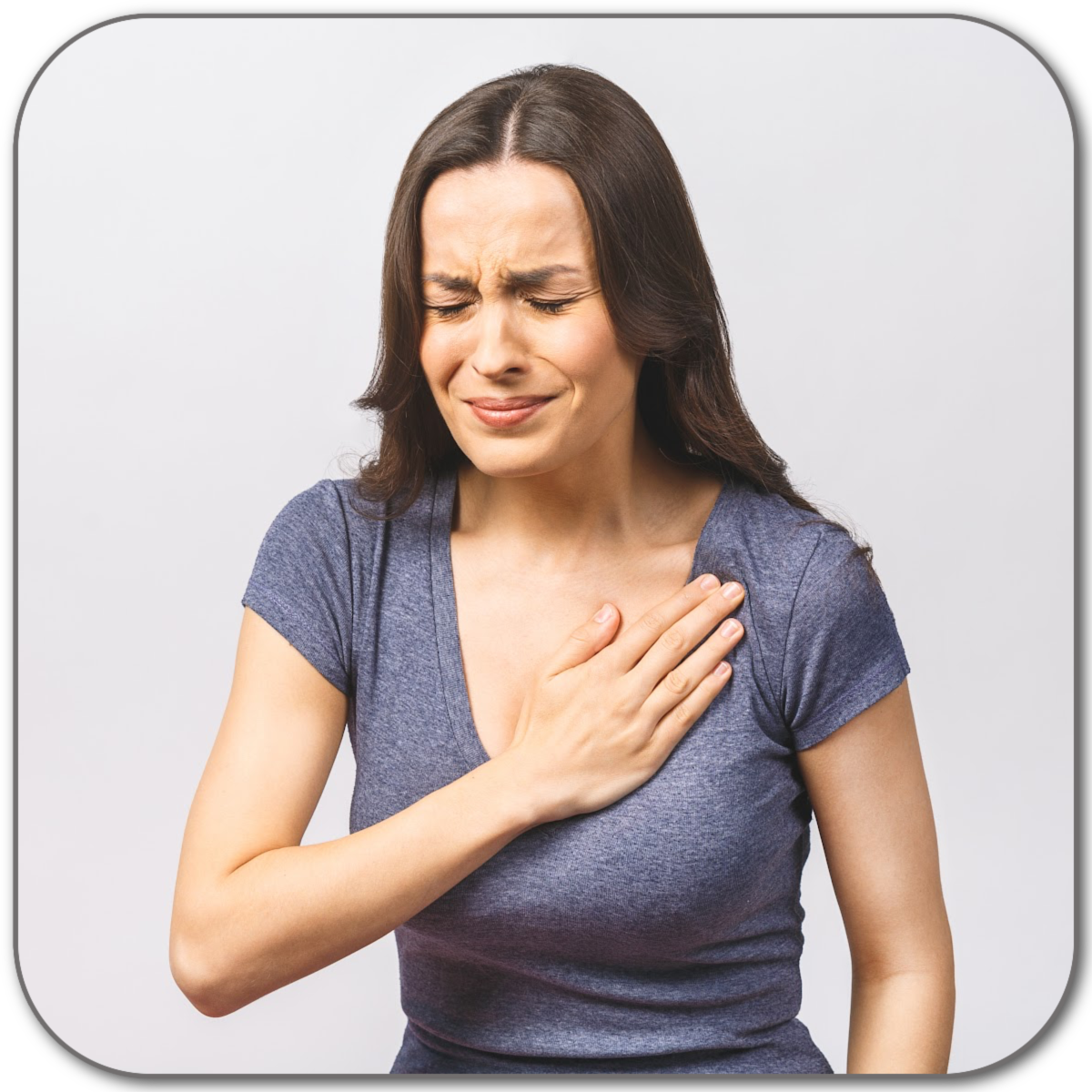A woman with dark brown hair holding her chest with a pained expression, possibly experiencing chest discomfort or chest pain.
