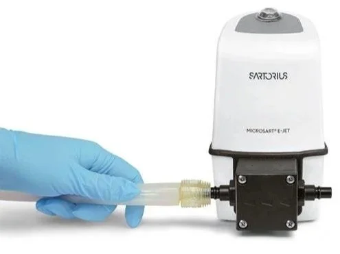 Una persona con guantes azules ajusta un tubo en una máquina Sartorius para laboratorio.
