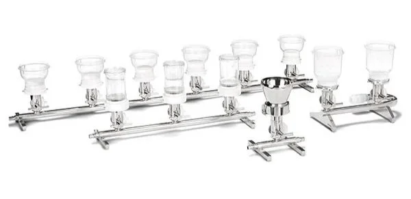 Instrumento de cristal de laboratorio con varios vasos en soporte de metal.