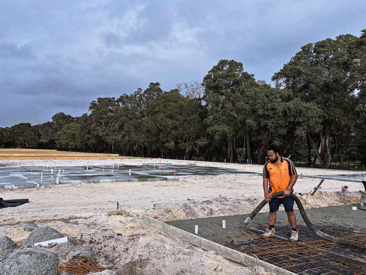 SWCP pump operator guiding concrete line on an active construction site Perth