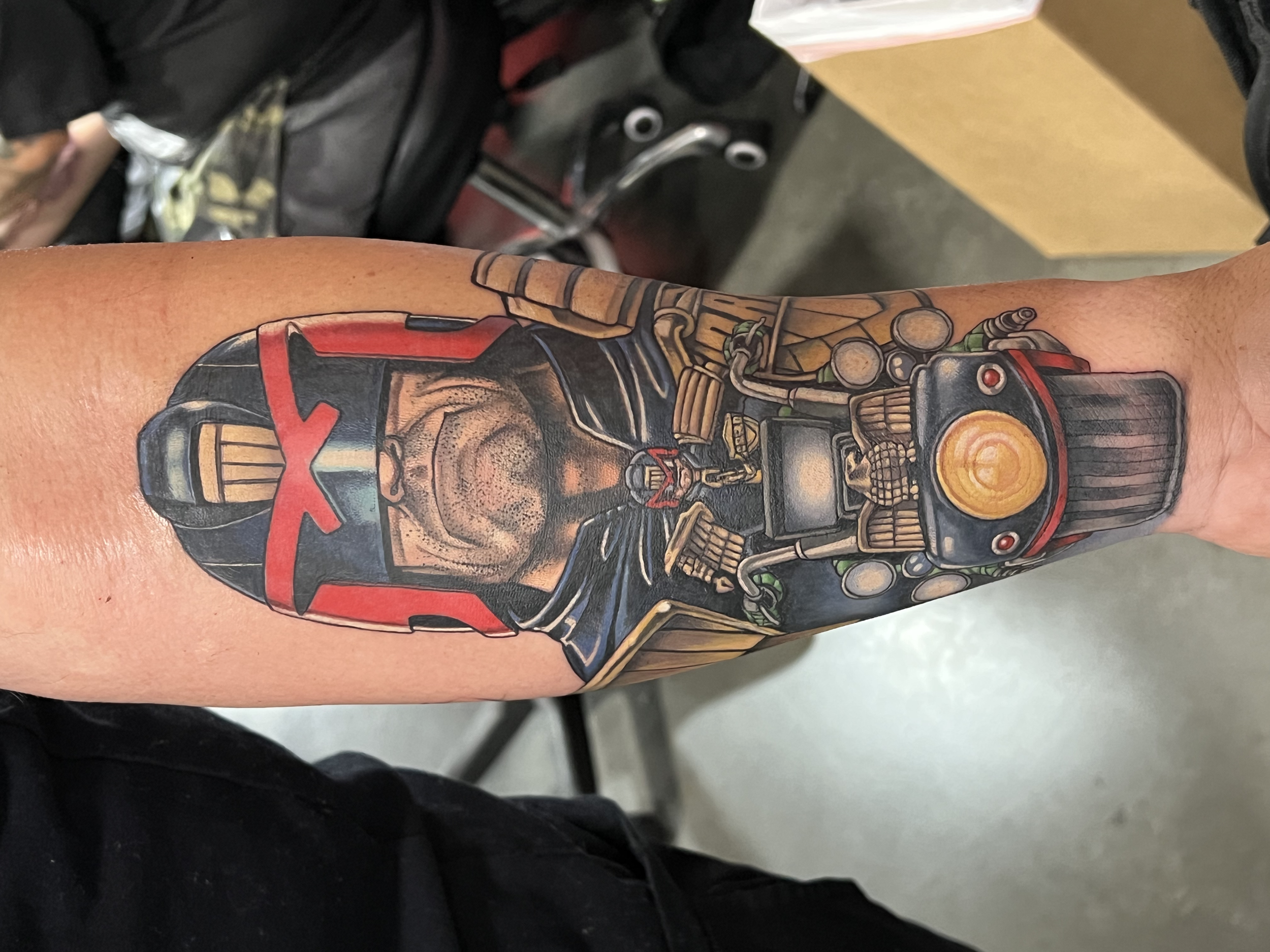 Colorful tattoo of a robotic bear on a person's arm.