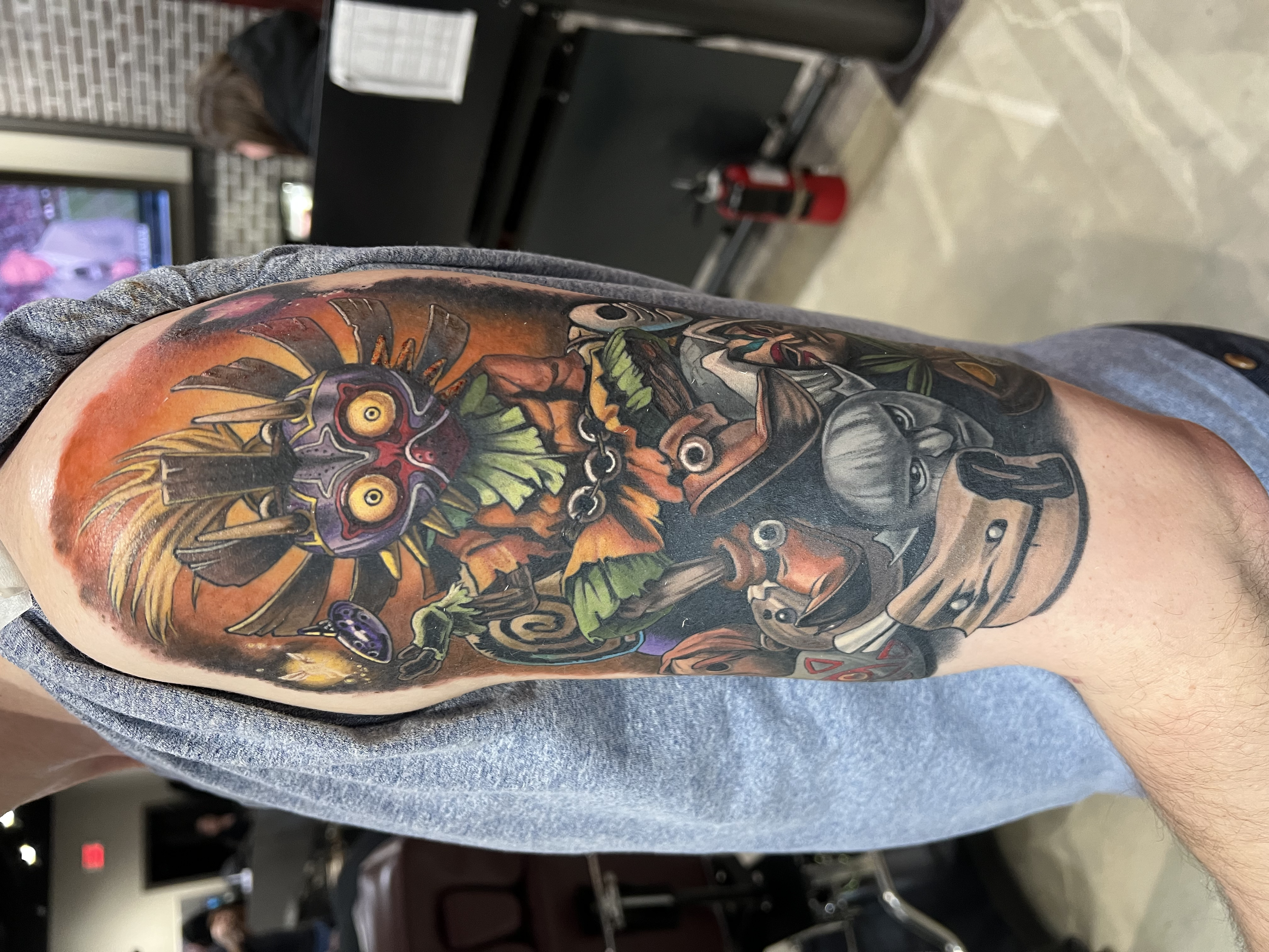 Colorful tattoo sleeve featuring abstract and fantasy elements on person's arm